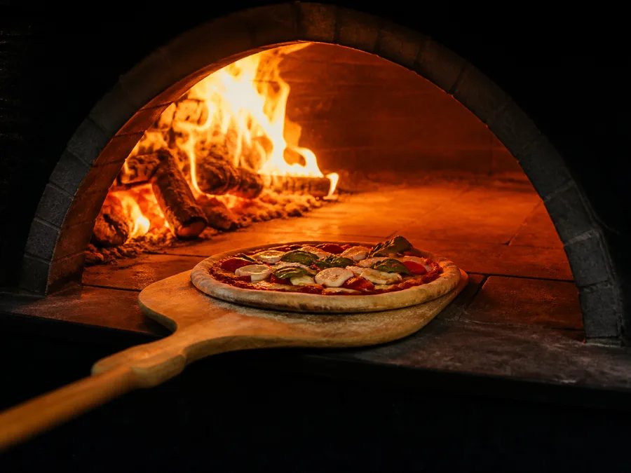 Pizza baking inside a stone oven